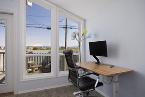 Comfortable desk setup with large windows for natural light and scenic productivity.