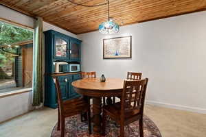 Gather around this cozy dining nook for shared meals, morning coffee, or card games with forest views.