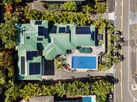 Drone view showcasing the home, pool lanai, and rooftop solar.
