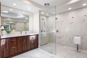 Spa-like ensuite with wide vanity space, natural stone finishes, and modern lighting.