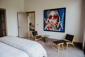 Slumber in the guest bedroom with a large bed and a unique art piece on the wall.