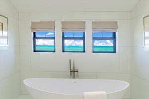 Soak in luxury with an oversized tub and framed tropical views.