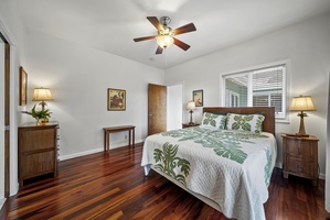 Spacious bedroom featuring calm tones and views of lush greenery, offering a peaceful setting for quiet mornings or reading time.