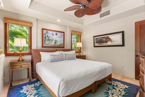 Guest bedroom in warm tones with ceiling fan and plush bedding.