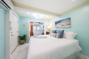 White bedding and its own split A/C in a bright, easy guest room.