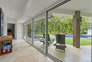 Sliding glass doors opening directly to the pool deck—step into your tropical oasis.