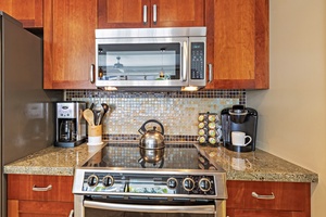 Premium appliances, granite counters, and tropical charm fill the kitchen at Hokulani 214.