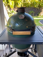 Enjoy tasty charcoal grilling or smoking on The Green Egg grill, perfect for preparing delicious outdoor meals.