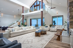 A welcoming and airy living space with vaulted ceilings and wall-to-wall windows, offering unobstructed ocean views for a serene living experience.