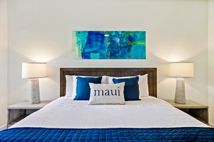 The primary bedroom features a plush king-sized bed with vibrant blue accents, offering a comfortable and relaxing space