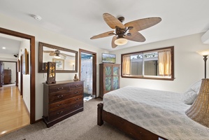 Guest bedroom with ensuite access and warm wood furnishings.