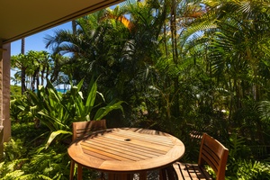 Intimate bistro table tucked among lush tropical foliage.