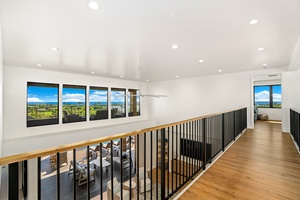 Your upstairs hallway offers stunning panoramic views through floor-to-ceiling windows, creating a bright, airy space to pause and admire the scenery.
