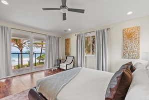 The primary suite in the upper level has large windows and ocean views.
