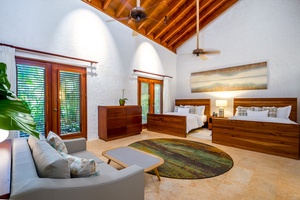 Inviting guest bedroom with two beds and a cozy sitting area.