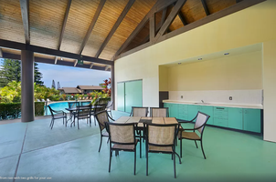 Covered lanai with dining table and poolside access, ideal for alfresco meals and sunset toasts.
