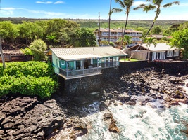See The Cottage’s prime oceanfront location, perched above the rocky shoreline with lush tropical surroundings.