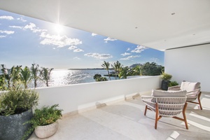 Spacious balcony with comfortable seating and ocean views.