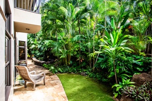 Private backyard garden space with stone path and lawn.