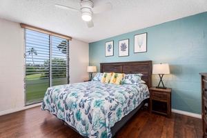 Primary bedroom w/ King bed, ceiling fan, golf course/ocean views, and ensuite.