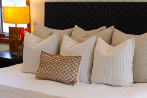 Sink into plush linens and luxurious pillows that invite your best night's sleep. The soft textures and warm lamp create a cozy sanctuary.