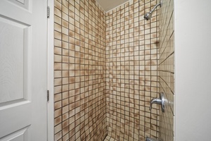 Refreshing tiled walk-in shower with a sleek design, ideal for rinsing off after a day at the beach.