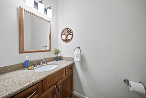 A closer look at the ensuite bath—modern fixtures, a large mirror, and natural finishes create a soothing space to refresh after a beach day.