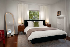 Rest peacefully in this sunlit bedroom with soft linens and calming garden views.