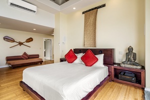 Primary bedroom features a king bed, plush linens, and serene coastal decor for restful nights.