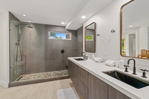 Spa-style ensuite bathroom with dual sinks and stone-accented walk-in shower.
