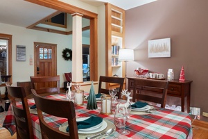 Dining area illuminated by a Christmas tree, capturing the essence of the holidays.