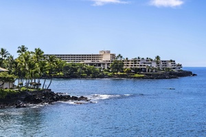 Oceanfront resort nestled along pristine coastline with tropical palm trees and crystal-clear waters.