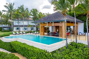 Luxurious oceanfront pavilion, featuring an infinity pool, sun loungers, and a covered dining area perfect for enjoying the coastal views of Casa De Campo.