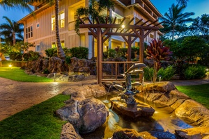 Beautifully lit resort grounds with tranquil water features, perfect for a peaceful evening walk.