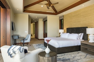 Reverse view of primary suite featuring California King bed, vaulted ceilings, wall-mounted flat screen TV, and desk.