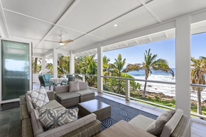 Covered upper-level balcony of the main house with cozy seating and sweeping views of Waiʻanae coast.