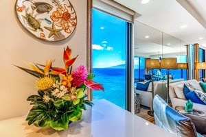 Tropical blooms frame the view as the lanai door opens to endless ocean at Mahana 1119.