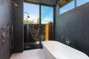 The spa-like downstairs primary ensuite (Bathroom 3) has a large soaking tub and an outdoor shower.
