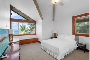 Guest bedroom with vaulted ceilings, ocean views, and natural light.