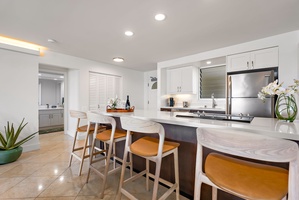 Casual breakfasts or happy hour bites feel elevated at this oversized kitchen island—complete with bar seating and ambient lighting.