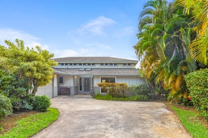 Arrive in style at the home’s front entry framed by lush tropical landscaping.