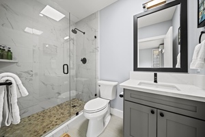 Enjoy a modern bathroom with a glass walk-in shower and sleek, updated finishes.