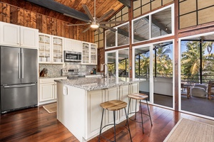 Cook in your bright, airy kitchen with tropical views through floor-to-ceiling windows while island seating invites conversation.