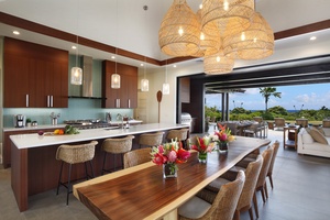 Kitchen and dining area showcase natural wood tones, pendant lighting, and open-air flow for an elegant tropical vibe.