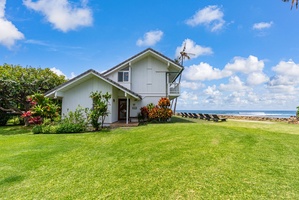 Charming beachfront property featuring tropical gardens and pristine oceanfront location with expansive lawn area.