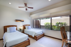 Cozy third bedroom with vaulted ceilings, ceiling fan, and twin beds—ideal for younger guests or friends sharing.