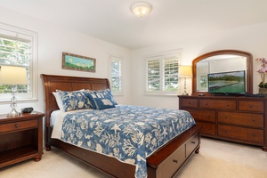 Drift off to peaceful sleep in your elegant bedroom, featuring rich wood furnishings and beautiful blue botanical linens.