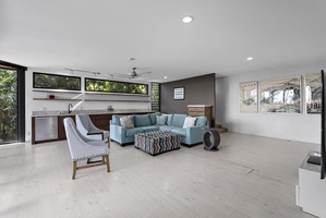 An airy upstairs living space with modern, sectional seating, perfect for relaxation and gatherings.