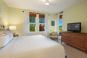 The primary suite featuring a king bed, soft natural light, and garden views.