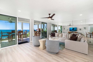 Spacious living room with floor-to-ceiling lanai access and modern costal décor.
